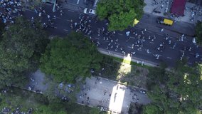People walking along Buenos Aires streets after final victory of soccer World Cup 2022, Argentina. Aerial top-down orbiting directly above