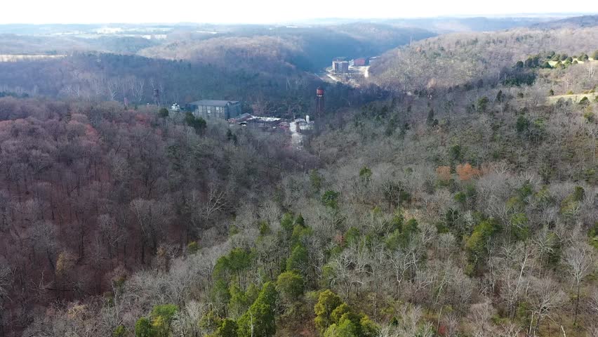 Aerial overview through mountains revealing Castle and Key Bourbon and Gin Distillery in Frankfort Kentucky on McCraken Pike Rd on a bright sunny day mid-winter with long shadows. 1080p 60fps