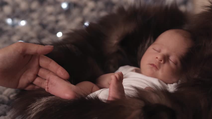 mom caressing the legs of her newborn baby.
