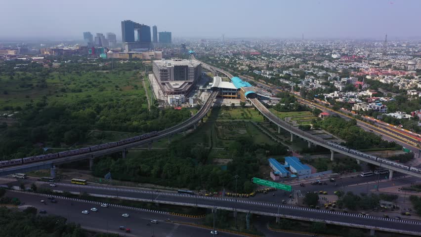 An aerial shot of the Delhi Metro entering Botanical Garden Metro Station at Noida,NCR,India 
