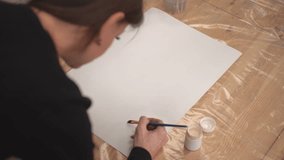 the girl applies glue to the canvas. High quality 4k footage. live video