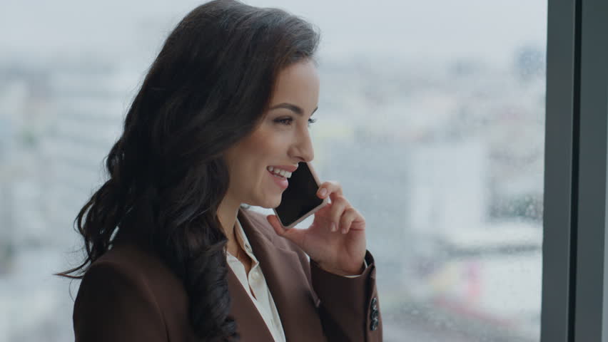 Smiling woman office manager chatting phone standing at window close up. Attractive elegant business consultant talking with clients using modern smartphone. Happy worker consulting on telephone. | Shutterstock HD Video #1098253695