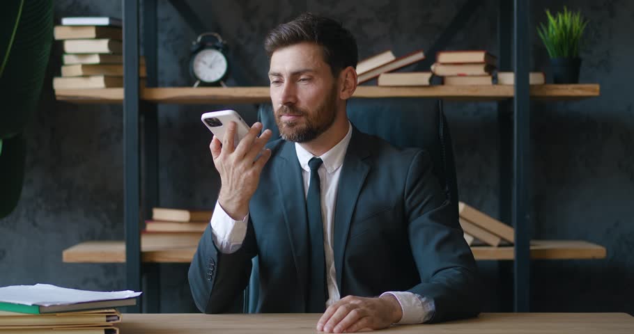 Angry boss reprimands his subordinates on smartphone. Aggressive boss yelling over voice communication at his company employees in modern office. Bearded boss emotionally negotiates. Business concept Royalty-Free Stock Footage #1098257047