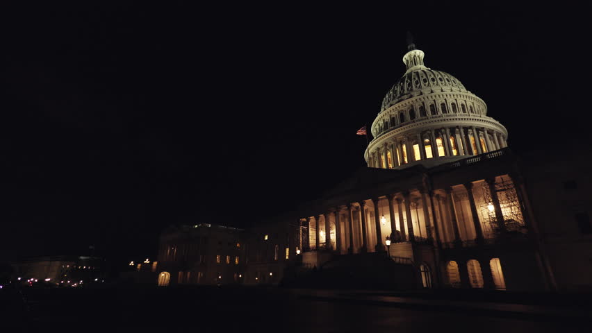 The United States Capitol Building in Washington, DC is captured in an ultra-wide shot as the camera pans from left to right during late autumn night.