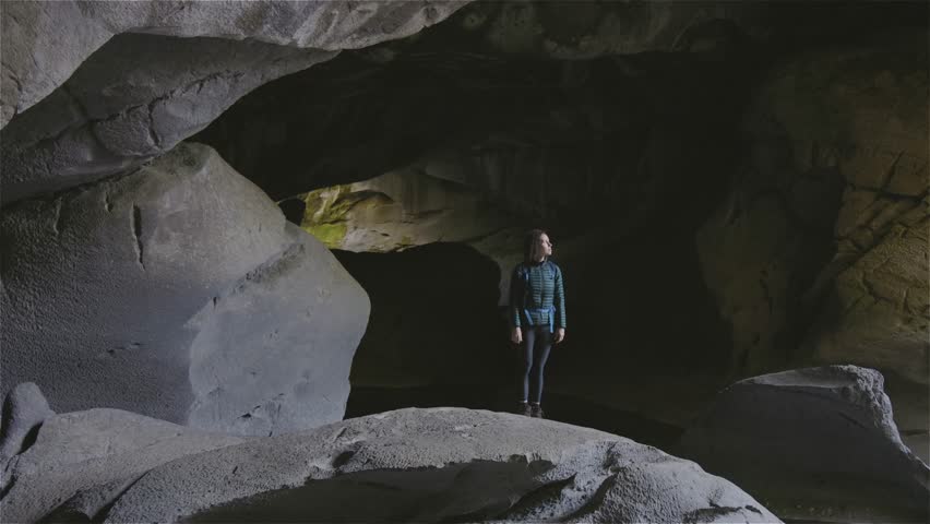Adventurous woman standing inside a cave. Adventure Travel. Little Huson Caves Park, Vancouver Island, British Columbia, Canada. Slow Motion Cinematic