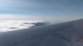 View of the clouds and the wing from the airplane window. Flight. Air travel