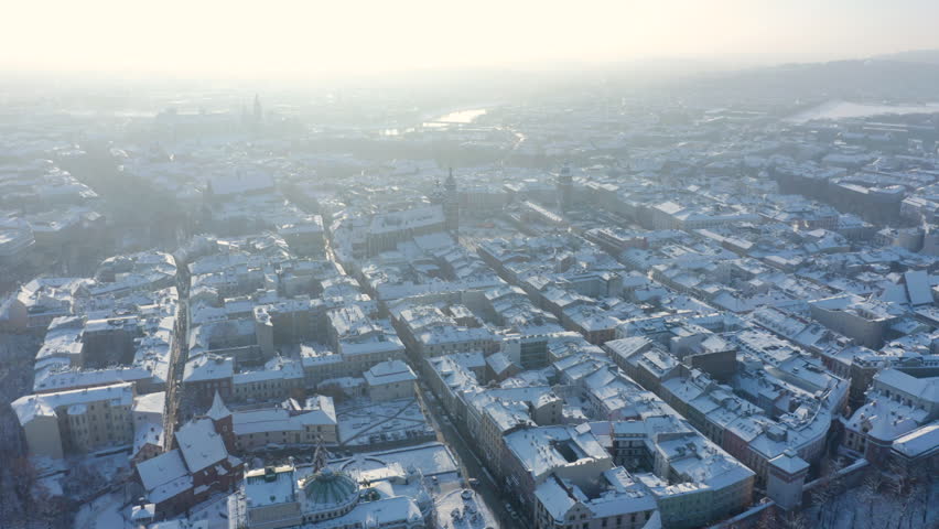 Aerial footage of the Old town square in the city of Krakow, capital city of Poland. Historic buildings. Winter season. Aerial view of Krakow during winter. Krakow main square during Christmas. 
