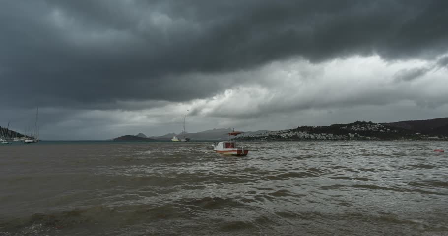 Fishing boat standing on the beach, rippling sea, dark clouds and the coming of the storm Bodrum, Bitez.