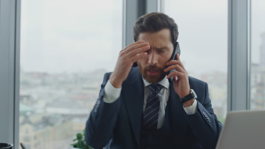Mad disappointed boss yelling phone sitting modern office desk reading bad news on laptop closeup. Aggressive businessman shouting on telephone dissatisfied work results. Manager ceo feeling desperate | Shutterstock HD Video #1098268031