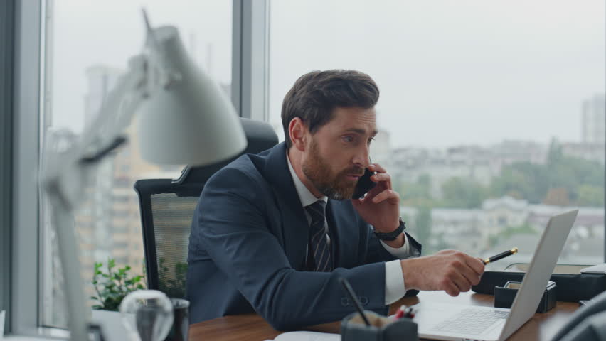 Stressed dissatisfied boss quarrelling calling phone in modern office closeup. Nervous emotional manager talking telephone loudly feeling anger. Furious employee discussing disagreement with partner | Shutterstock HD Video #1098268181
