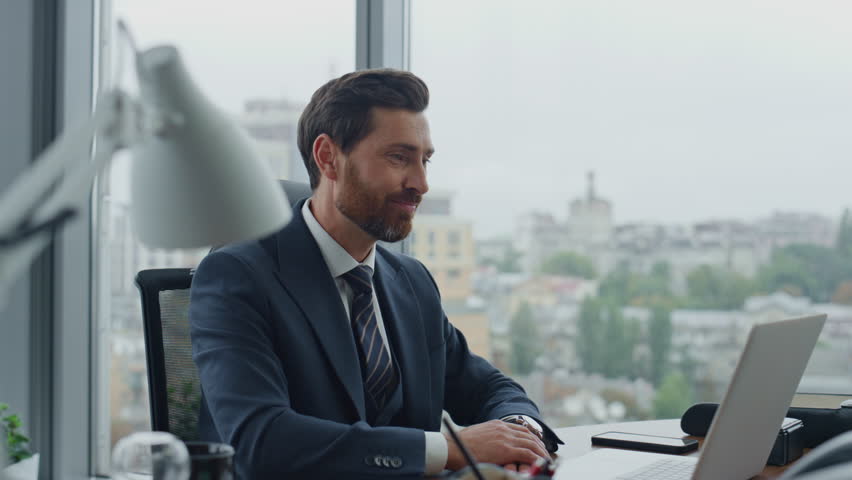 Happy businessman finishing online interview using laptop in modern luxury office close up. Smiling bearded manager waving hand to web camera ending video conference. Boss talking on internet meeting. | Shutterstock HD Video #1098268213