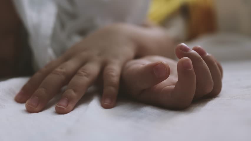 A toddler holding father hand during baby sleeping. Father taking care of her son kid happy family dream of health | Shutterstock HD Video #1098268495