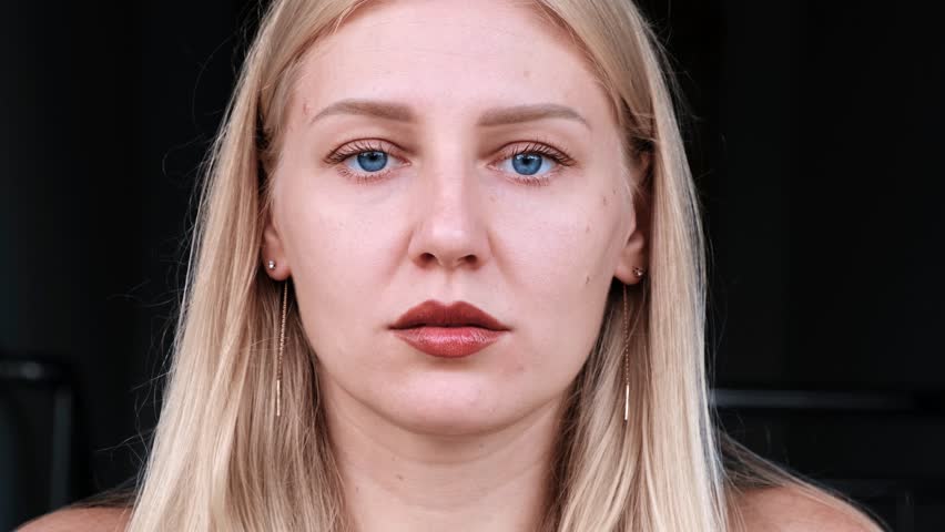 Emotion of sadness, sadness and disappointment. A shot to the head of a young blonde woman with blue eyes experiencing annoyance and regret. | Shutterstock HD Video #1098271281