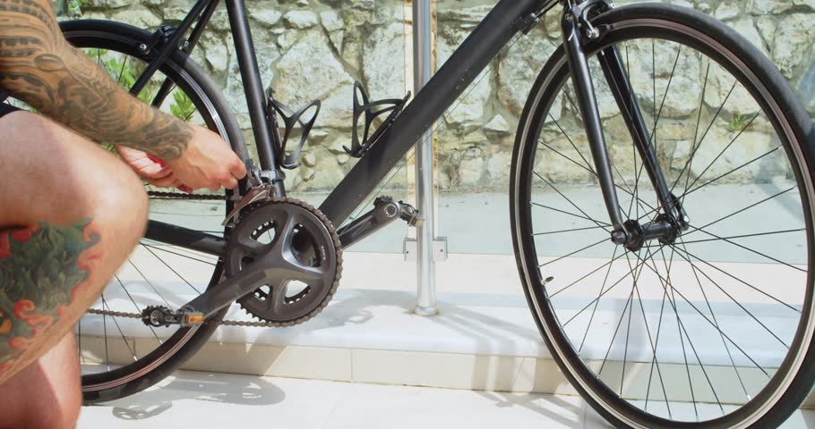 Male cyclist preparing his bike before to get into the road while standing on balcony