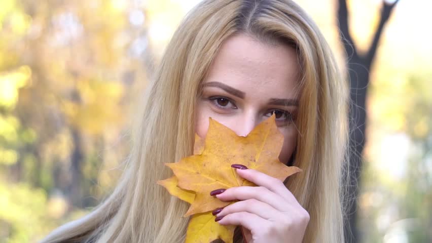 Slow Motion Lady gathering leaves autumn nature background. Girl dreamy face