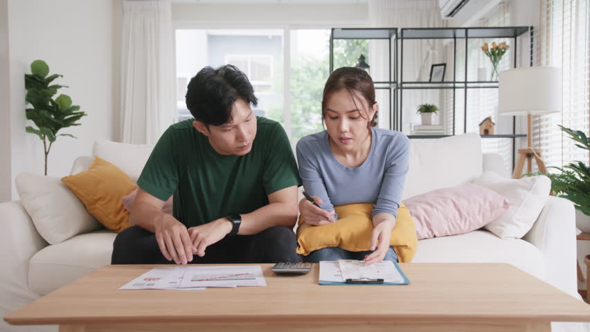 Rising high cost of living in low poor income asia people family. Past due bill debt home loan money issue young adult asian couple man woman worry shock sad tired stress in raise tax rate crisis Royalty-Free Stock Footage #1098283129