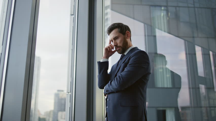 Serious financial specialist discussing work affairs on phone conversation standing office wearing elegant suit. Confident bearded business man solving company problems using phone communications. | Shutterstock HD Video #1098288537