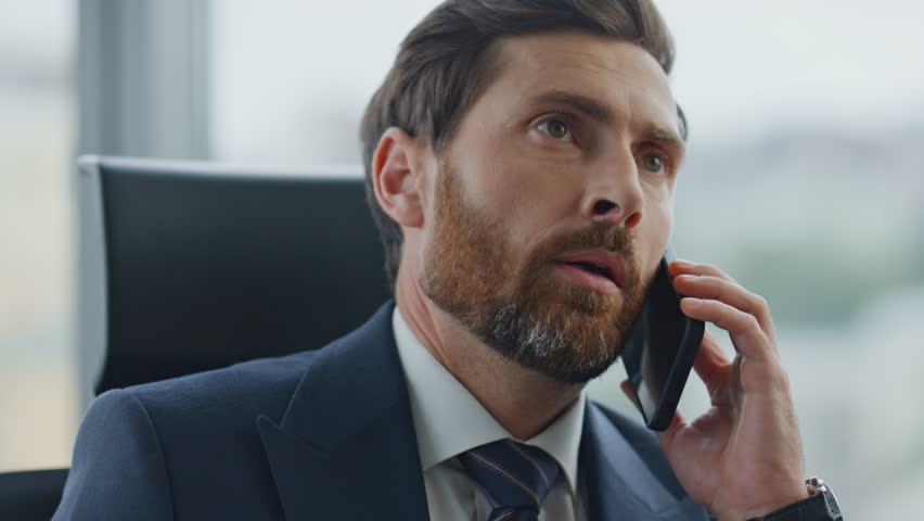 Confident man professional lawyer talking phone sitting modern office close up. Bearded business owner negotiating on smartphone feeling dissatisfied with work results. Project manager finishing talk. | Shutterstock HD Video #1098288603