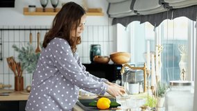 Pregnant woman washes vegetables for cooking dish in cosy kitchen. Brown-haired housewife prepares ingredients and washes thoroughly - Powered by Shutterstock - Get 15% off with code: PIKWIZARD15