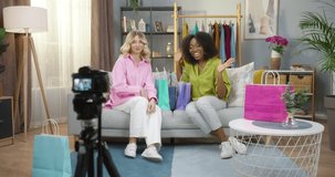 Professional set of camera with smart action camera on tripod over young multiracial women working at home while recording their blog about online shopping. Live streaming for entrepreneur concept
