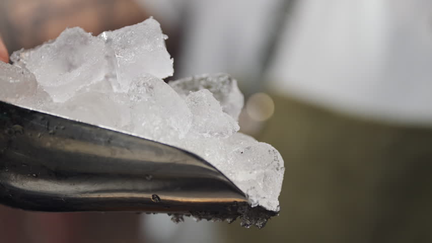 Slow motion video of a bartender pouring ice into a glass. The process of making cocktails at the bar. High quality 4k footage - Powered by Shutterstock - Get 15% off with code: PIKWIZARD15