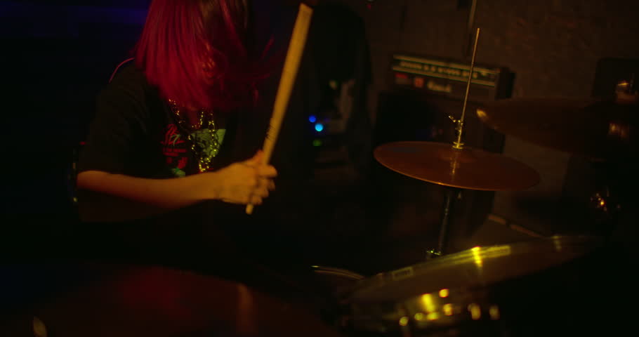 Drummer girl with red hair playing drums kit fast. Energetic moment during performance at the concert. Camera in motion moves from left to right. Girl drummer concert concept. | Shutterstock HD Video #1098295697