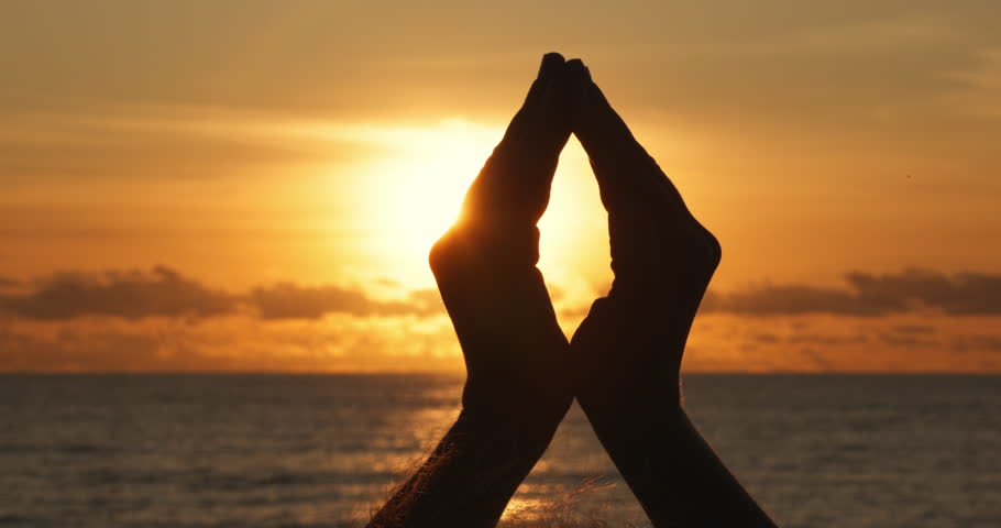 Woman hand close up at golden sunset, sun flare human hand inside, peace and meditation simbol, love, relax and healthy life concept, Silhouette of girl hand at sunset, sea ocean beach scene