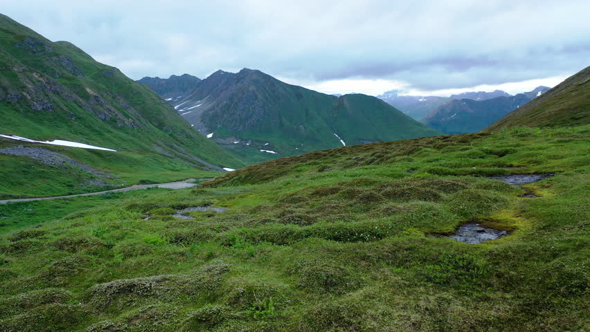 Aerial view of Hatcher Pass, Alaska. Mountain pass through the Talkeetna Mountains from above. Summer Alaskan landscape 