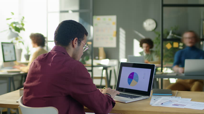 Timelapse of financial analyst working with business data on laptop and communicating with colleagues during workday in office | Shutterstock HD Video #1098299857