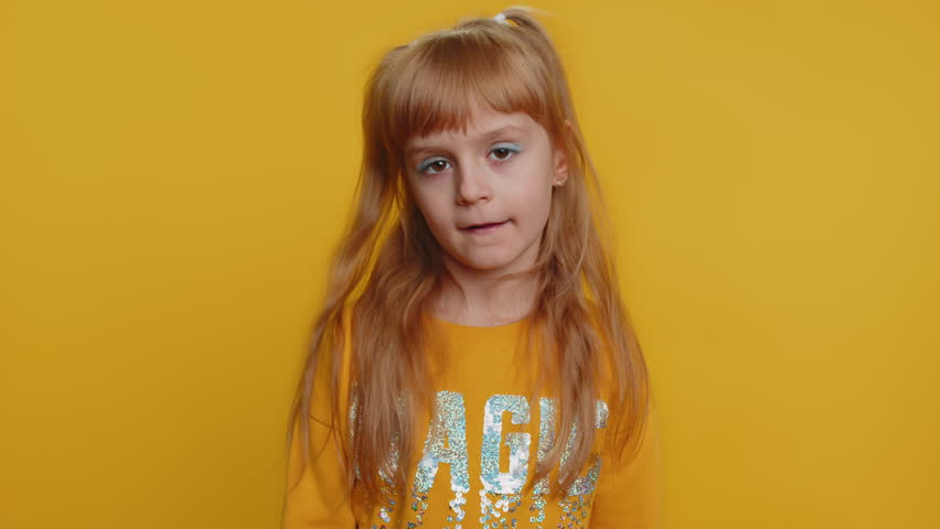 Cheerful funny bully young preteen child girl kid showing tongue making faces at camera, fooling around, joking, aping with silly face, teasing. Little toddler children isolated on yellow background Royalty-Free Stock Footage #1098303675