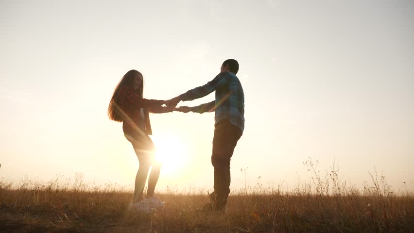 Happy family couple play round dance silhouette at sunset. people in park fun dream concept. happy family a boyfriend with and friend lifestyle girl spinning hold hands in park on grass | Shutterstock HD Video #1098308085