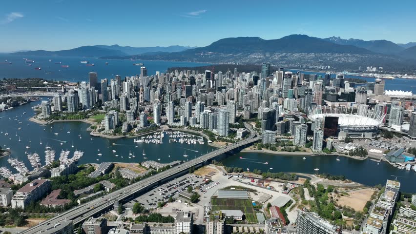 An aerial drone view of the downtown of Vancouver with modern buildings and a port with moored boats