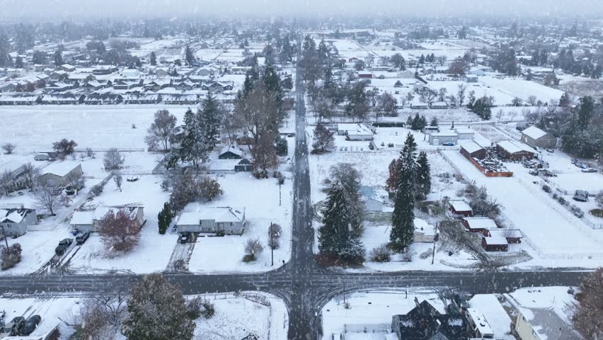 Aerial view of rural Spokane, WA with snow actively falling on the community.