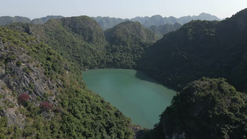 Shallow lake lagoon on steep rocky island in Ha Long Bay in Vietnam