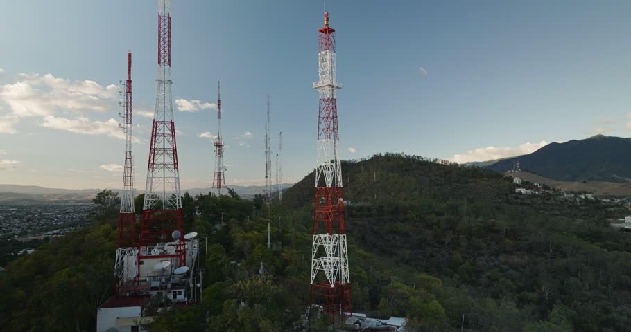 Aerial view at sunset of large telecommunications towers on a mountain in Oaxaca.