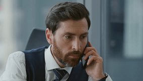 Serious boss answering phone call sitting modern company office close up. Portrait of middle-aged bearded businessman talking on smartphone about business processes. Manager consulting by cellphone. - Powered by Shutterstock - Get 15% off with code: PIKWIZARD15