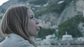 Side Portrait Of Beautiful Young Woman Blowing Bubble Gum With Amalfi Coast In Backdrop. closeup - Powered by Shutterstock - Get 15% off with code: PIKWIZARD15