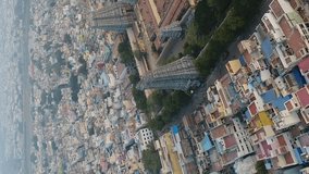 Vertical video of Aerial shot of huge Hindu temple in the middle of Madurai city buildings