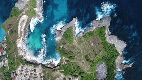 Vertical video of Aerial shot of a rocky coast with turquoise water