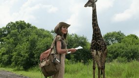 Young traveler woman looking at map. Young hiker traveling and hiking alone, female using map and wearing backpack. Summer tourism, wild nature. woman traveler with a backpack stands near a giraffe - Powered by Shutterstock - Get 15% off with code: PIKWIZARD15