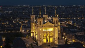 Establishing Aerial View Shot of Lyon Fr, Auvergne-Rhone-Alpes, France at night evening, Basilica of Notre Dame de Fourviere, pull out