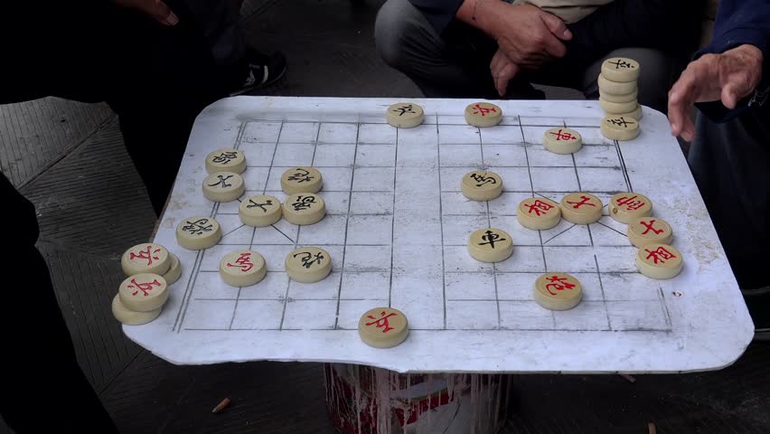 Chinese men is playing Xiangqi (Chinese chess).