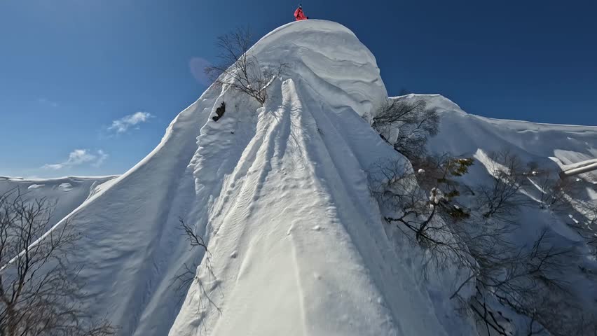 Sportsman skier extreme sport freeride downhill drop snow cornice mountain summit adrenaline race splash aerial view. FPV drone shot male ski professional athlete rider cliff valley sunny 50fps slo-mo Royalty-Free Stock Footage #1098344891