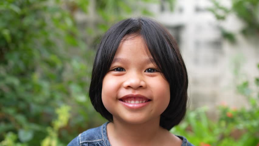 Portrait Funny little asian girl big smiling child looking at camera and pointing her cheeks, enjoying childhood testimonial concept, Positive child, 4k footage, Slow Motion Portrait | Shutterstock HD Video #1098345243