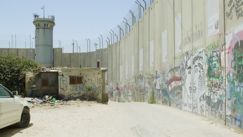 Graffiti on the west bank barrier with a security tower built for the Israeli-Palestinian conflict. Royalty-Free Stock Footage #1098345811