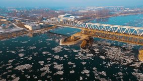 Old iron railway bridge spanning frozen river with floating ice floes during cold foggy winter. Beautiful snowy landscape in cold times. Concept of nature ecology preserving - Powered by Shutterstock - Get 15% off with code: PIKWIZARD15