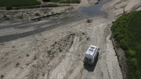 Drone shot of white van passing in campspot at river. adventure videos.