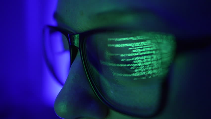 Woman analyst or programmer works at a computer in glasses, the eye is close-up, the reflection of the code in the lens of the glasses. Big database, calculations. Royalty-Free Stock Footage #1098354125