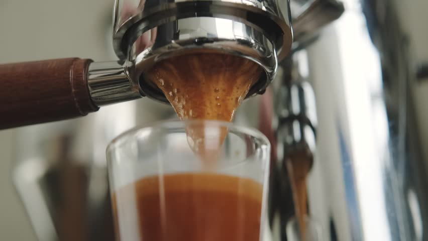 Pouring coffee stream from professional machine. Barista making double espresso, using filter holder. | Shutterstock HD Video #1098354369