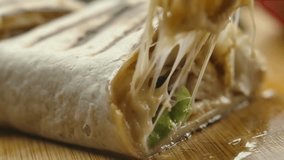 Super close-up of mexican burrito with melted cheese and Juicy pieces of meat and vegetables fall out of the burrito. High quality 4k footage - Powered by Shutterstock - Get 15% off with code: PIKWIZARD15